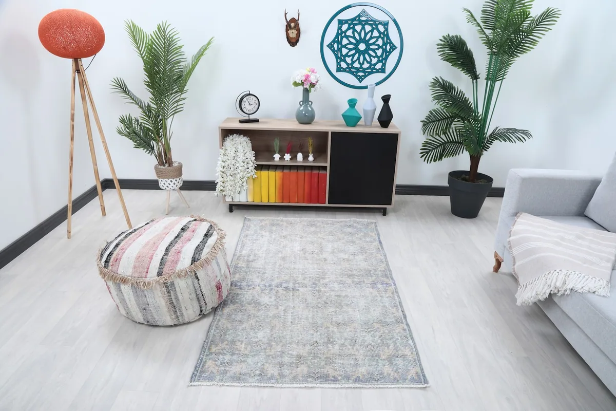 Vintage gray and blue rug placed in a modern living room setting