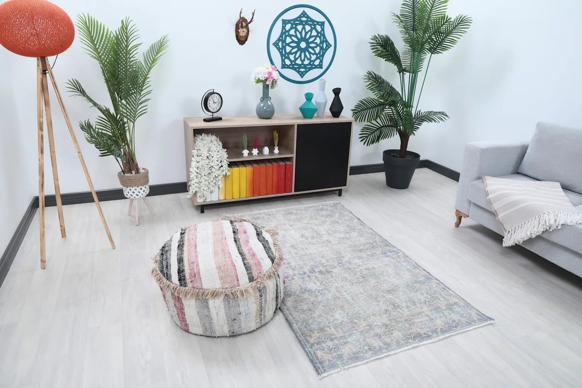Angle view of the rug in a living room with a pouf and sofa