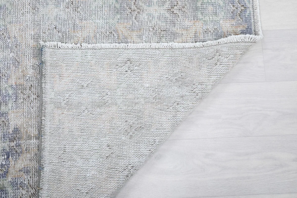 Corner of the rug turned over, showing the reverse side's construction