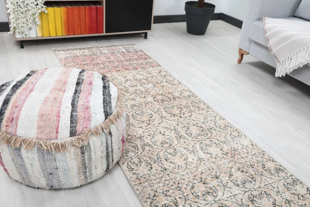 Close-up angled view of the runner rug, highlighting the beige field with charcoal patterns.