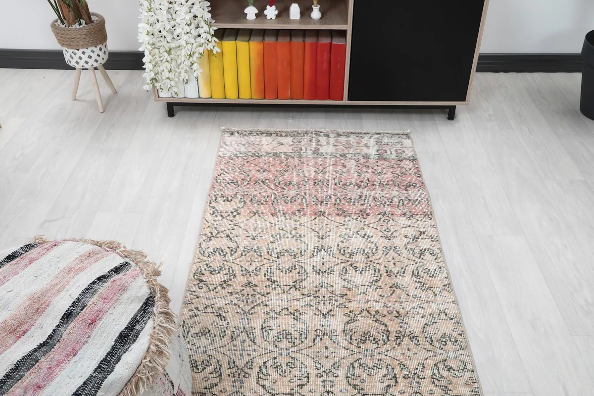 Overhead view of the runner rug in a room, focusing on the transition from beige to rose sections.