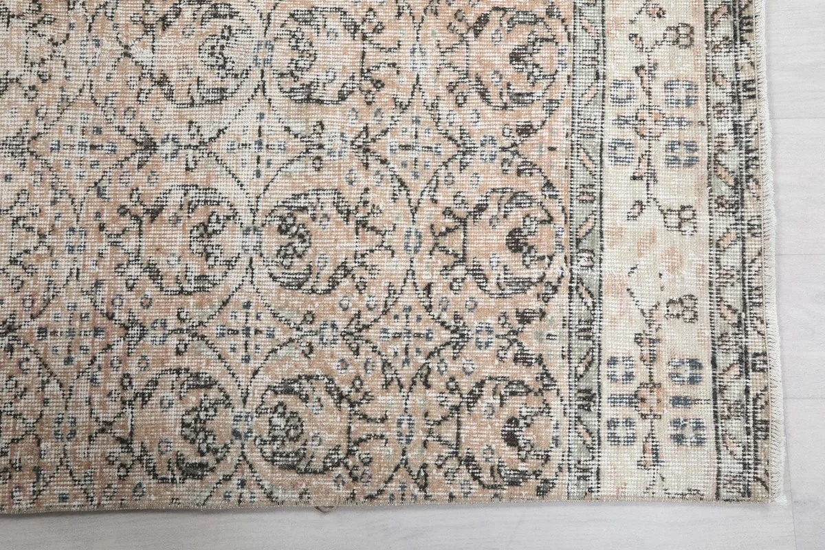 Detailed view of the beige section of the runner, showing intricate charcoal floral and geometric motifs.