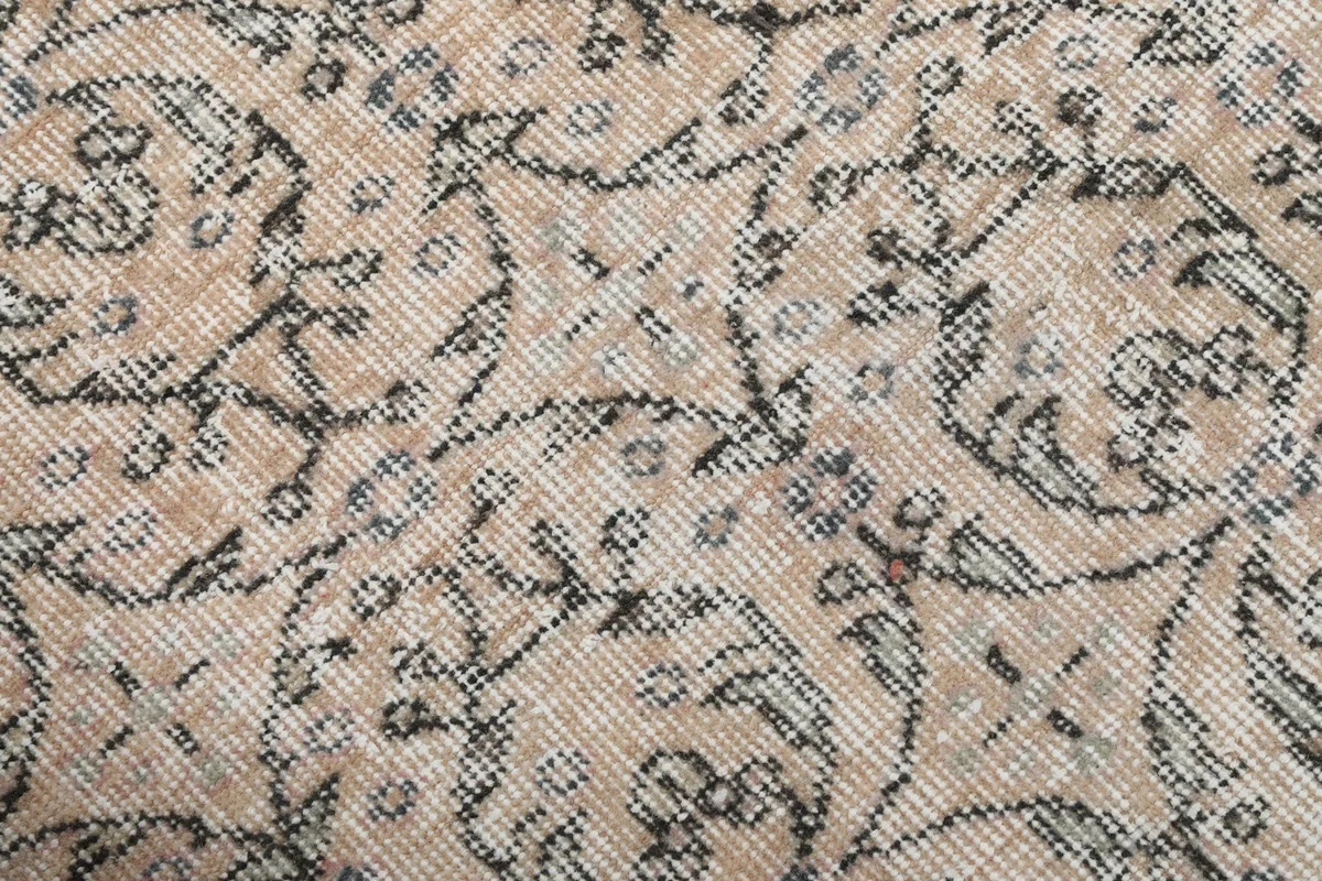 Close-up of the low wool pile, revealing the texture and subtle color variations of the beige and charcoal.