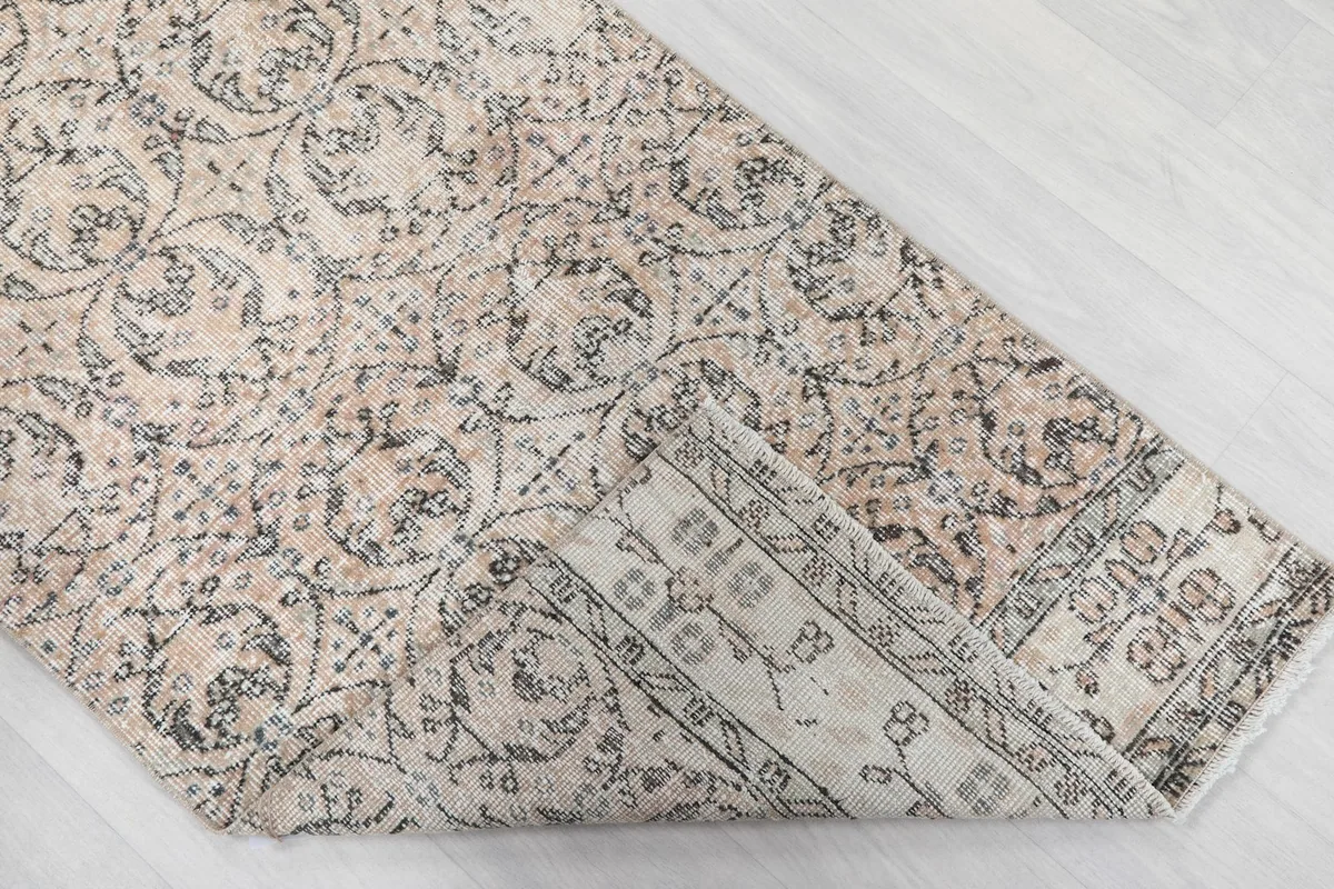View of the back of the hand-knotted rug, folded to show the cotton foundation and knotting.
