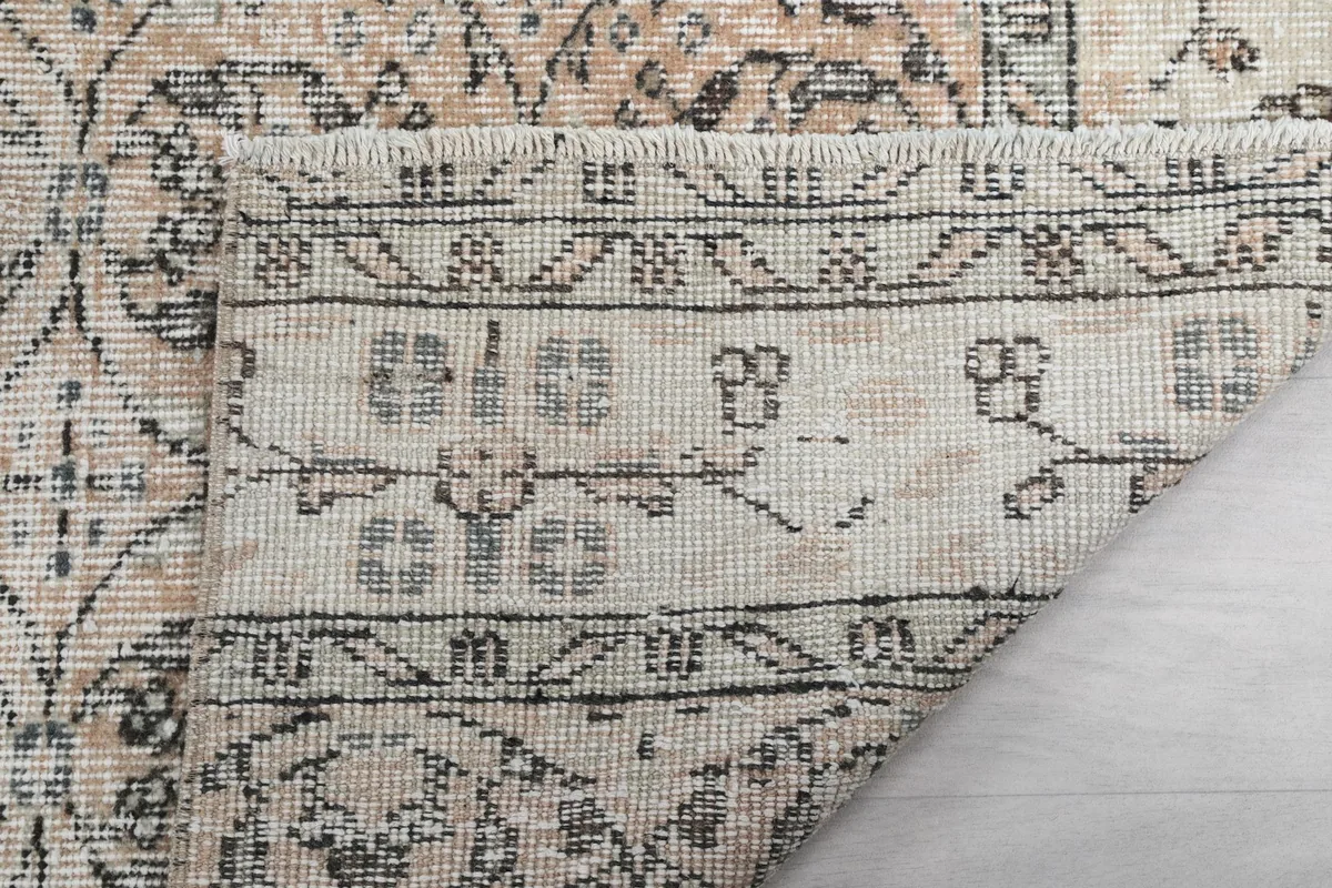 Close-up of the rug's back and fringe, revealing the construction and detail of the cotton foundation.