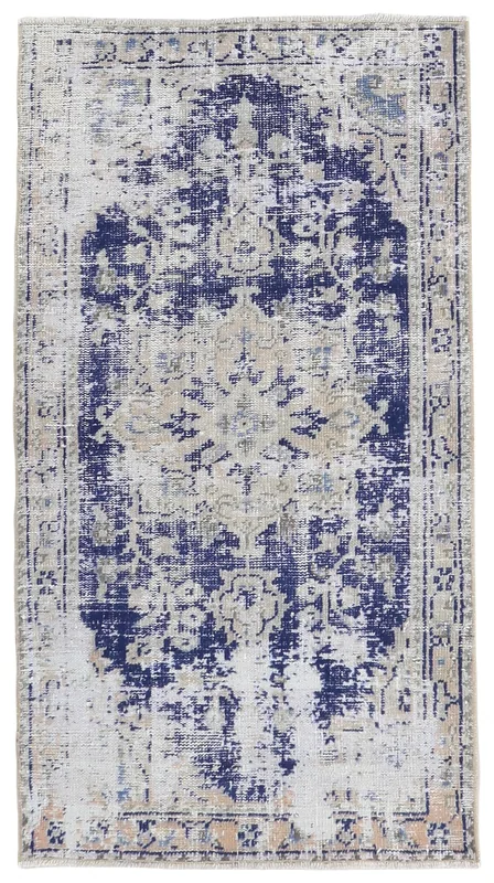 Full overhead view of the navy and beige distressed vintage Anatolian rug on a white background.