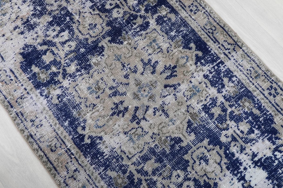 Overhead angle view focusing on the central navy and beige medallion design and surrounding geometric motifs.