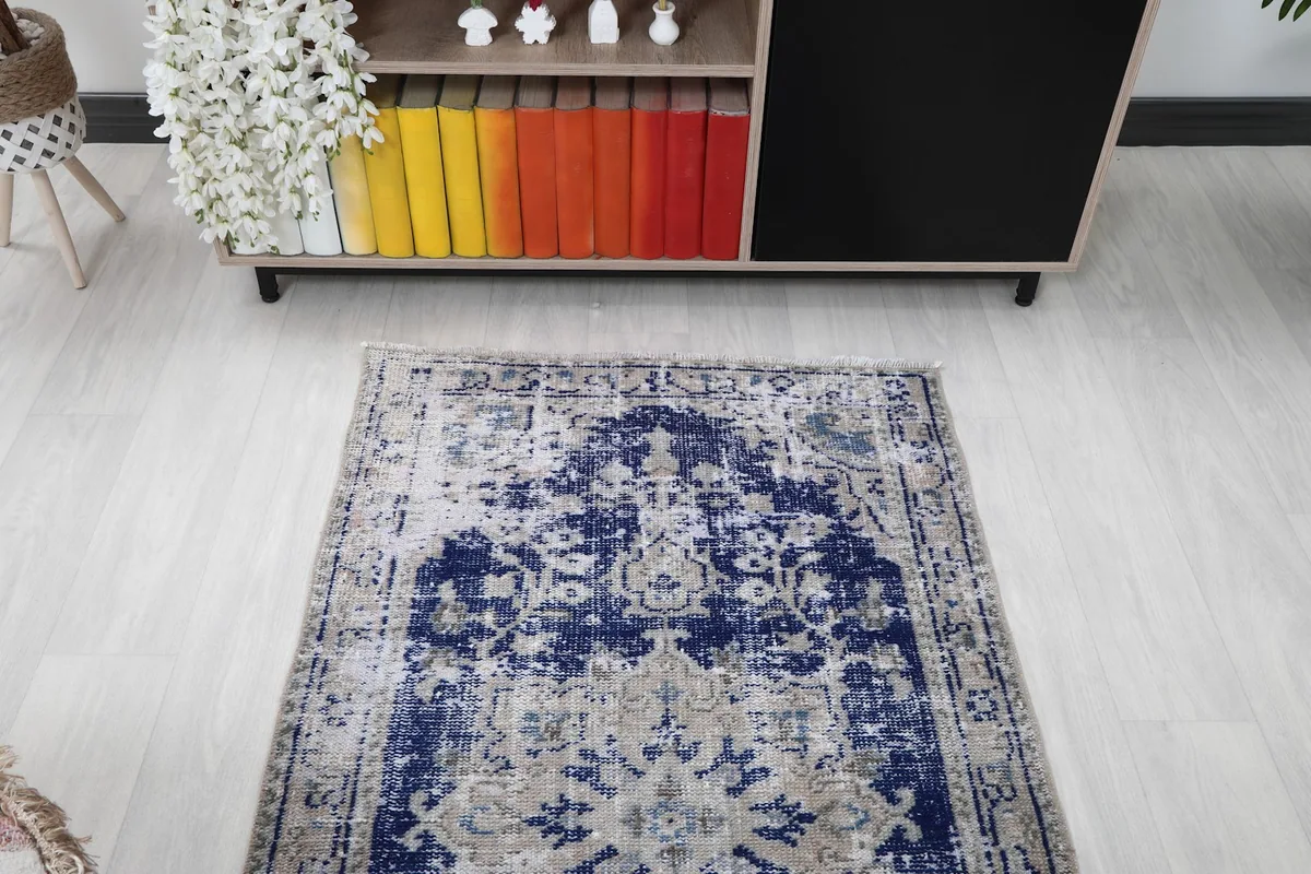 Direct overhead shot of the rug in a room setting, emphasizing its overall distressed design and colors.