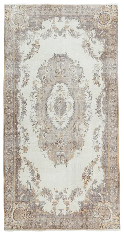Full overhead view of the ivory and brown floral medallion vintage rug on a white background.