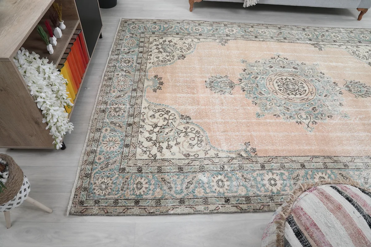 Wide angled view of the rug in the room, capturing its scale and the worn patina of the pile.