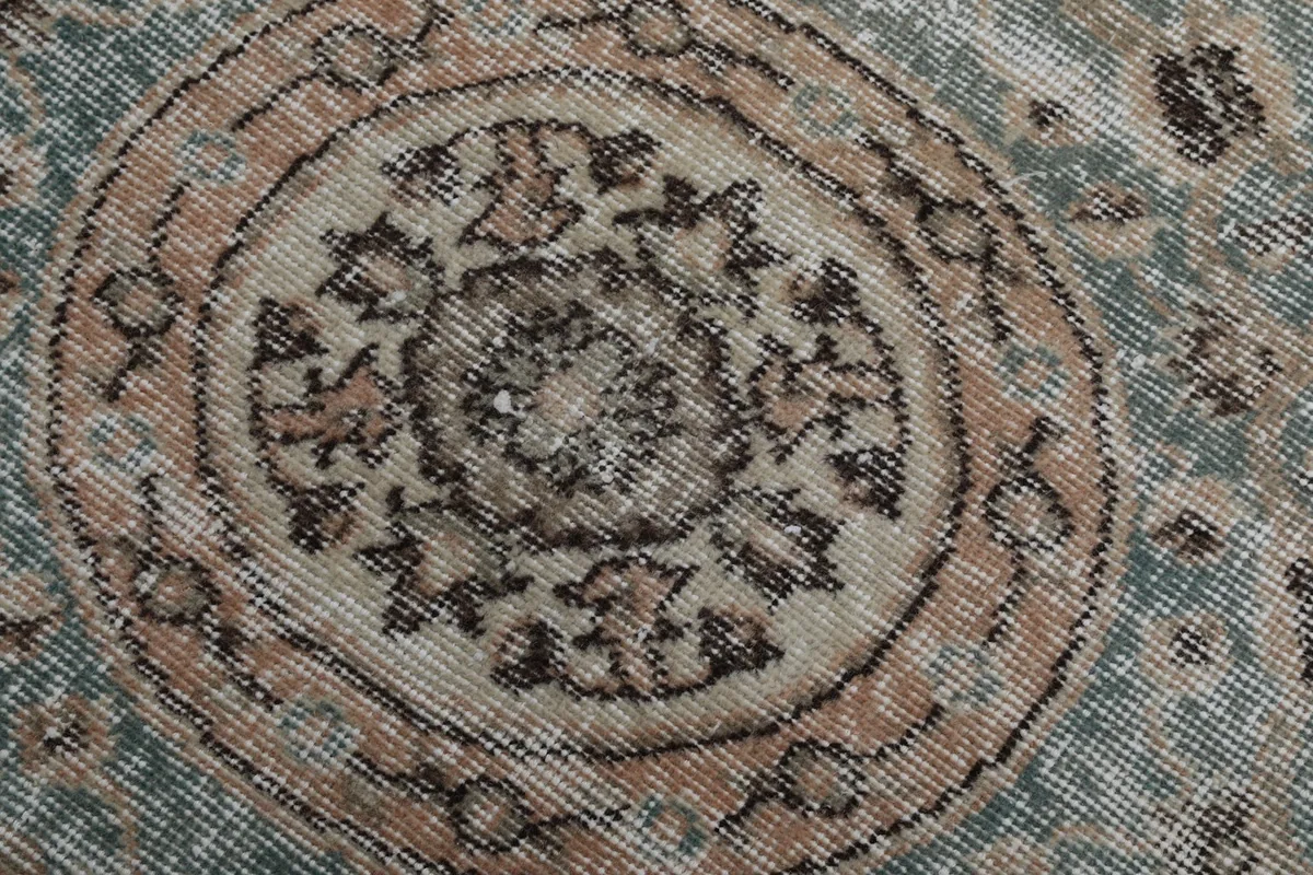 Macro detail of the hand-knotted wool pile showing the texture and colors within the medallion.