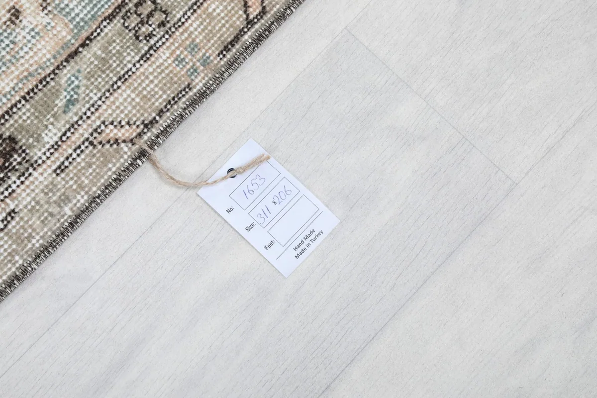 Tag on the rug's reverse side, confirming its origin and material as hand-knotted wool from Turkey.