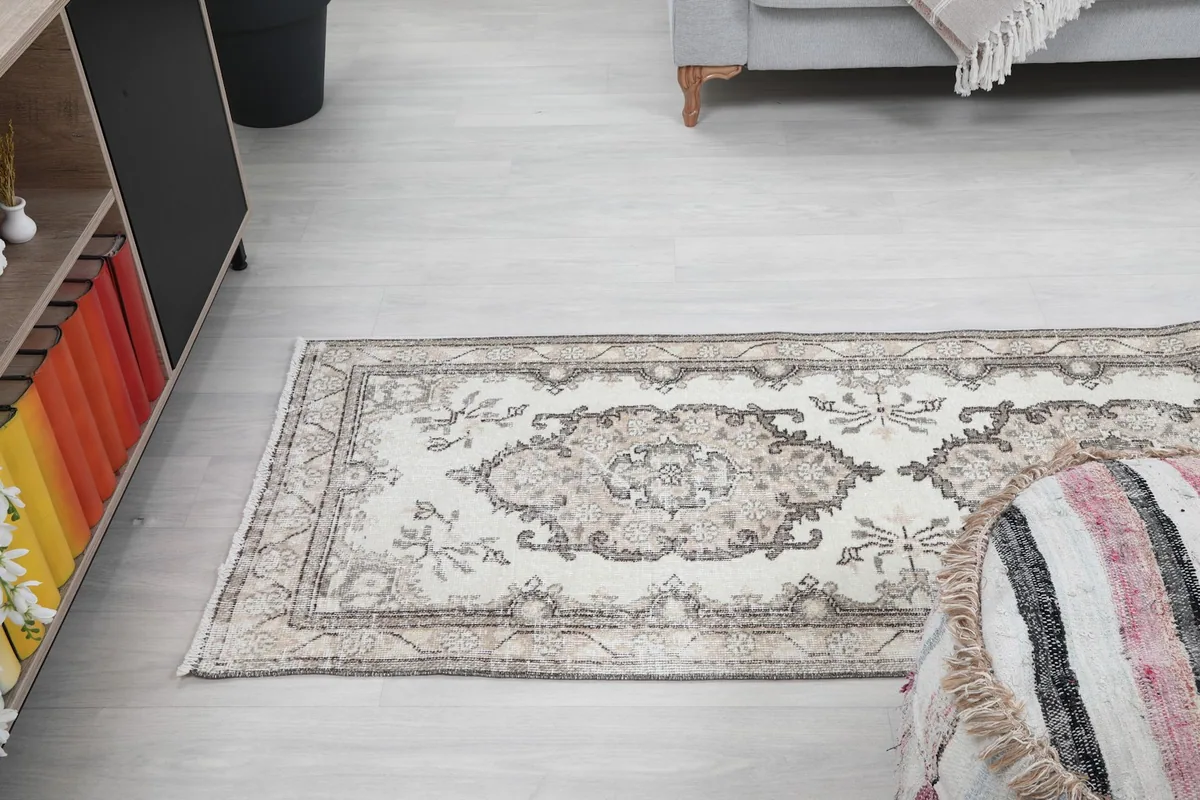 View of the rug from one end in a room, showing its integration with furniture