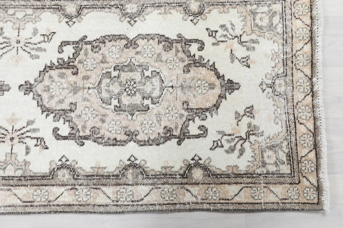 Detailed view of the rug's end, showing the border design and medallion motif