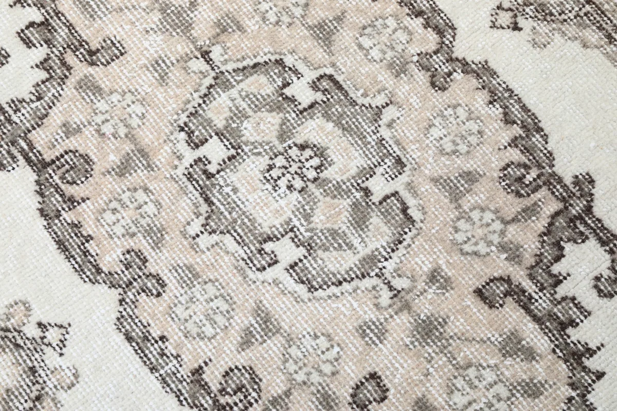 Close-up of the rug's surface, revealing the texture of the wool pile and intricate motifs