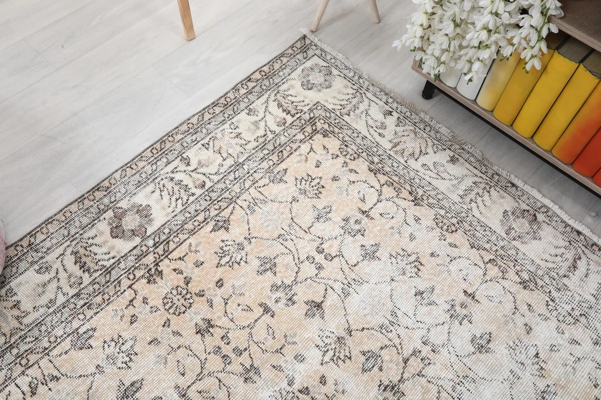 Corner view of the rug, showing the elegant border design and a glimpse of the room