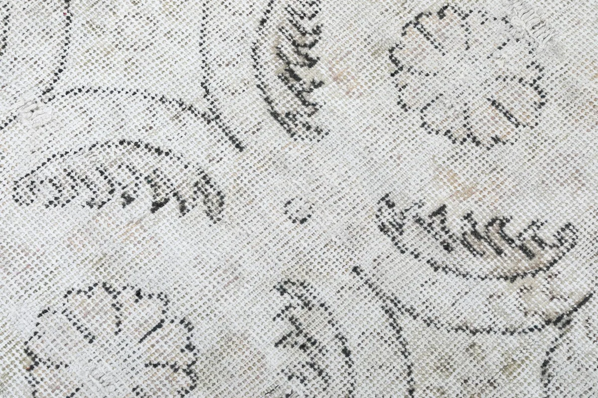 Extreme close-up showing the low pile and intricate knotting of the vintage wool rug