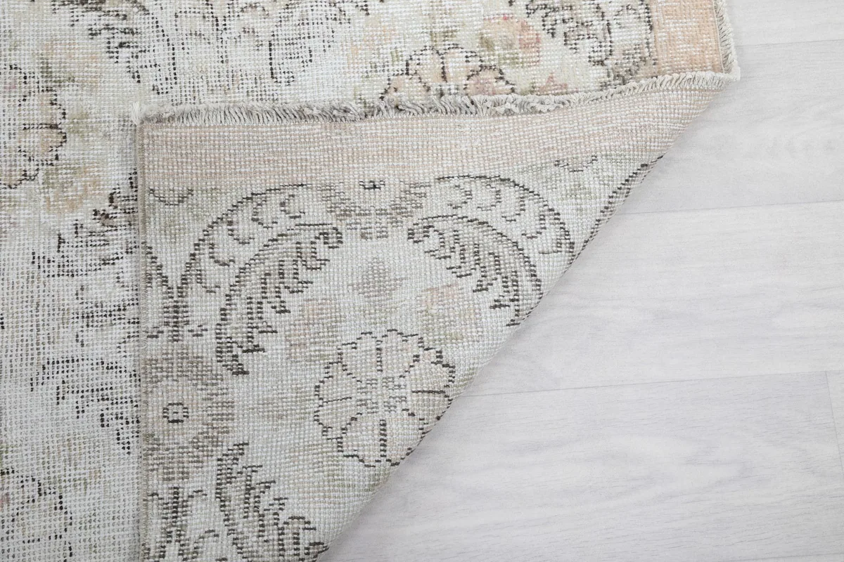 Underside of the rug, showing the hand-knotted cotton foundation and the reverse of the pattern