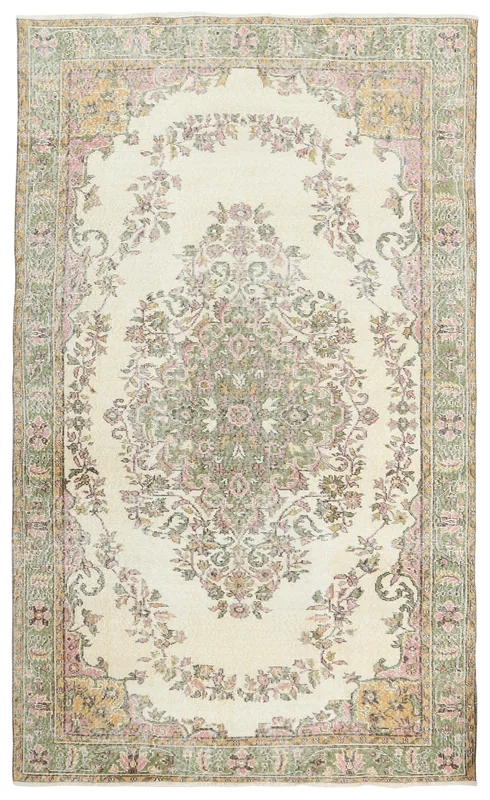 Full overhead view of the ivory, green, and pink floral medallion vintage Anatolian rug