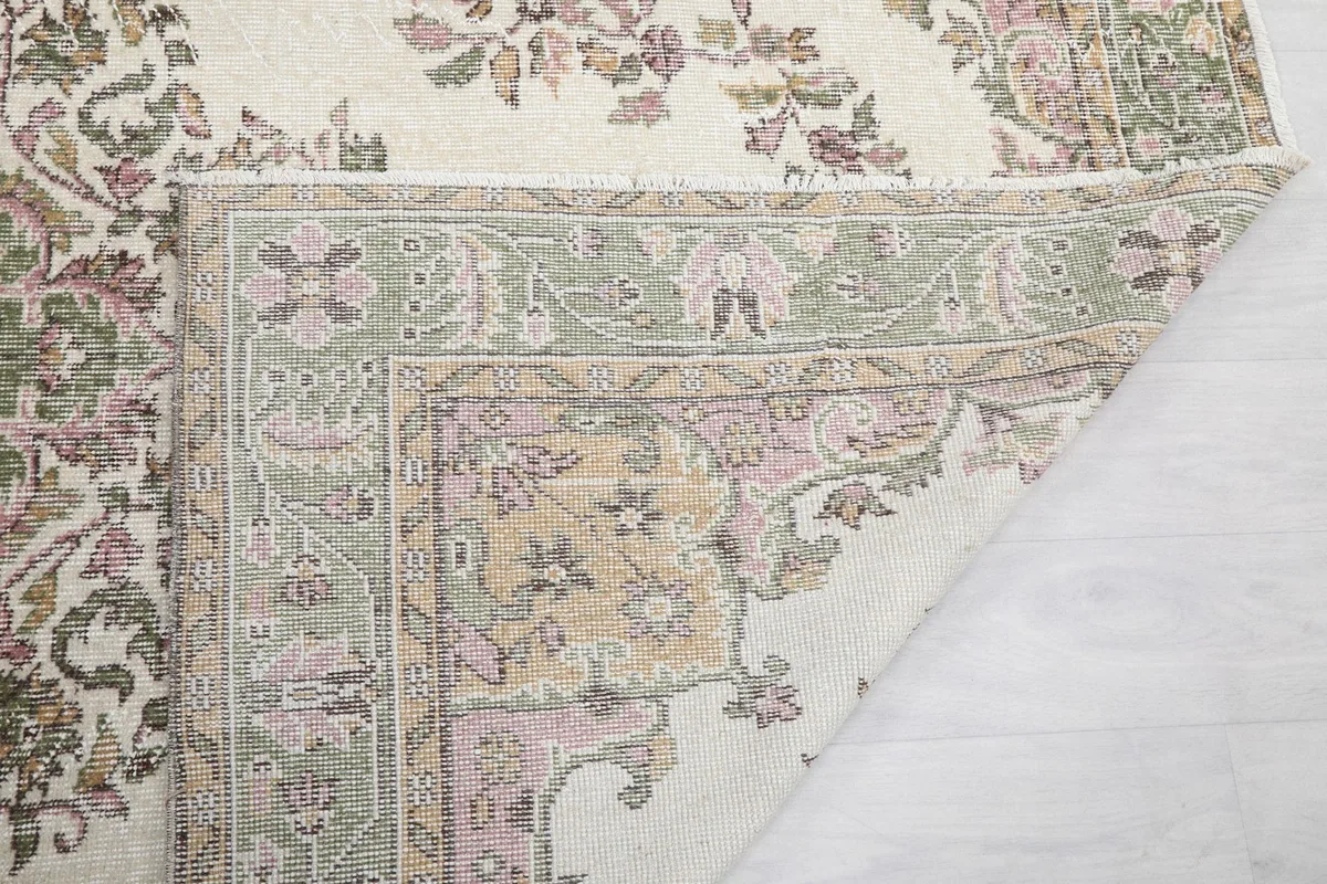 Underside view of the rug's corner, showing the hand-knotted construction and fringe
