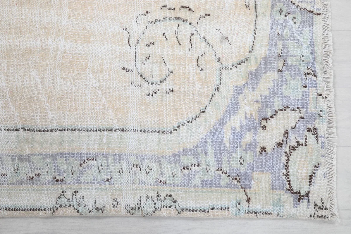 Detailed corner view of the gray border and fringe, highlighting the hand-knotted texture