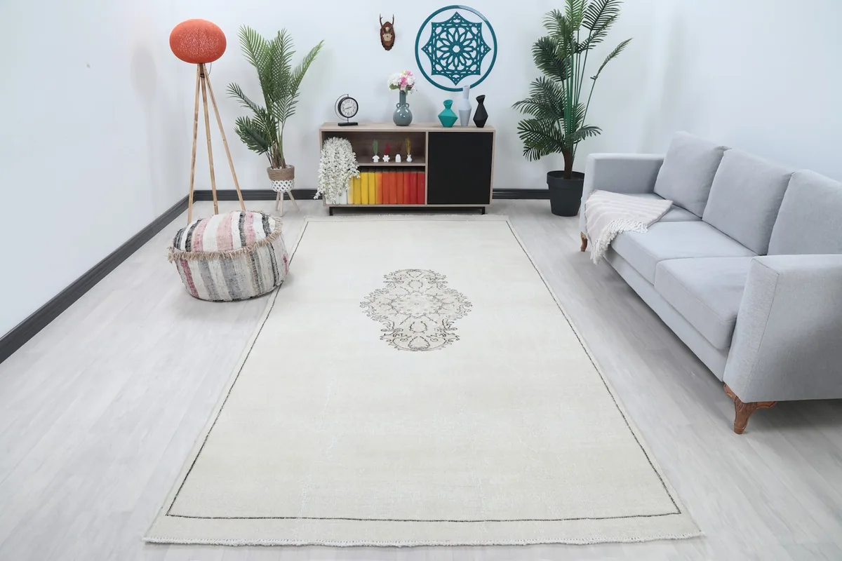 Ivory vintage area rug displayed in a living room setting with a light gray sofa and modern decor.