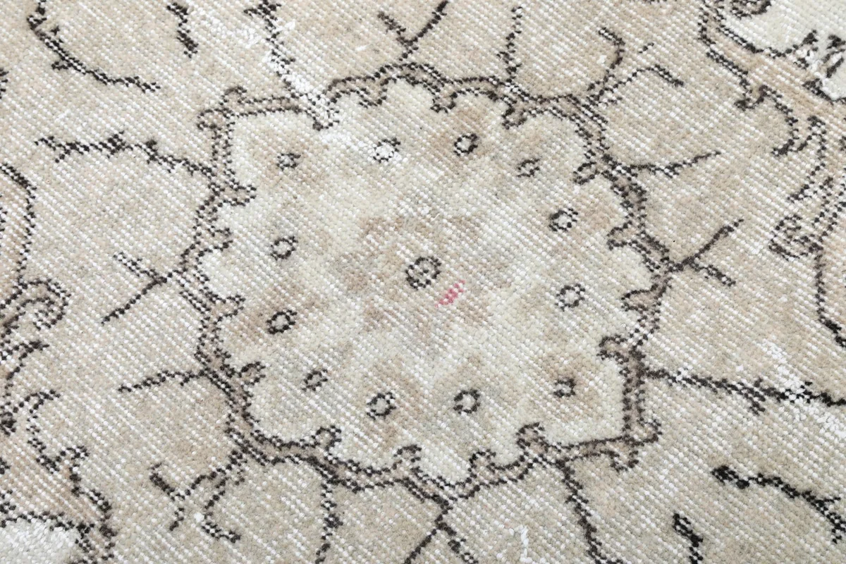 Close-up of the medallion's texture and colors, revealing the low pile and vintage character.