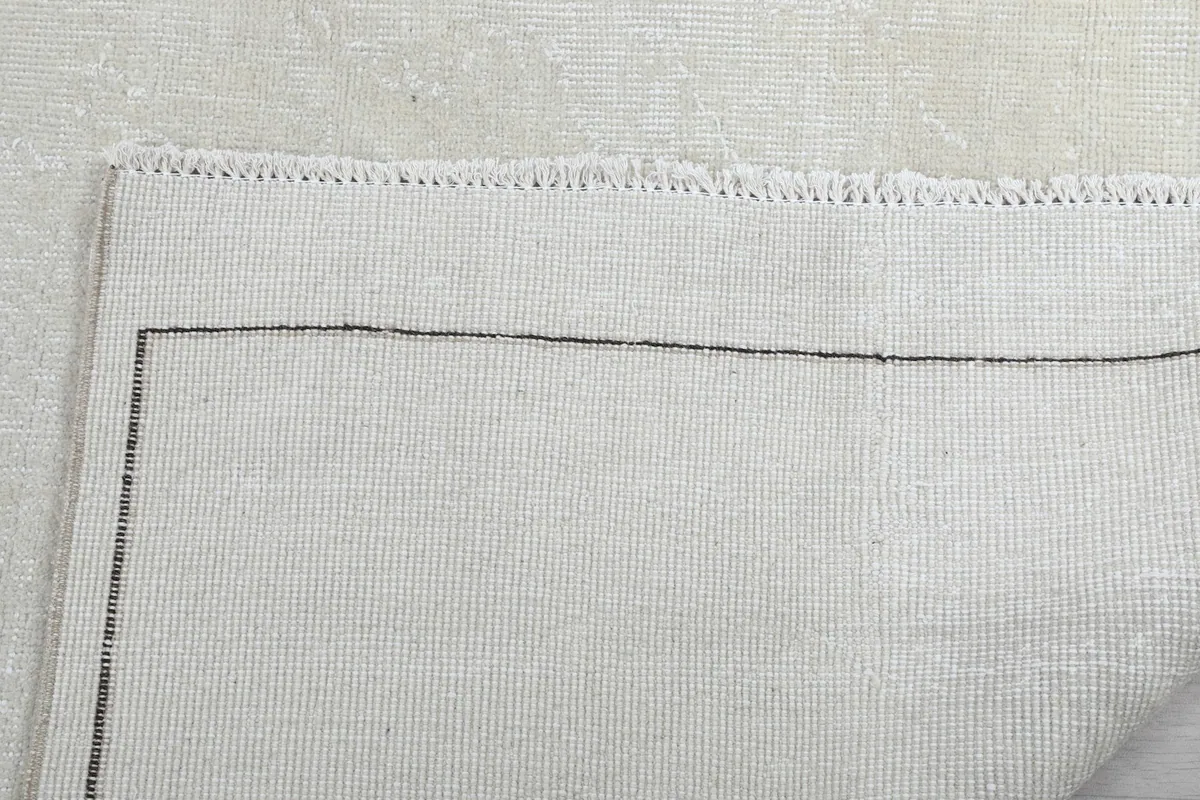 Close-up of the back of the rug and its fringes, demonstrating the quality of the cotton foundation.