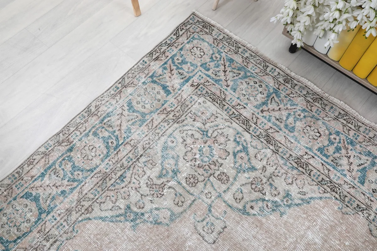 Corner detail of the rug, highlighting the blend of blue, beige, and tan colors