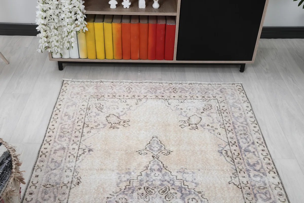 Angle view of the vintage rug showing its placement in a room with a cabinet in the background