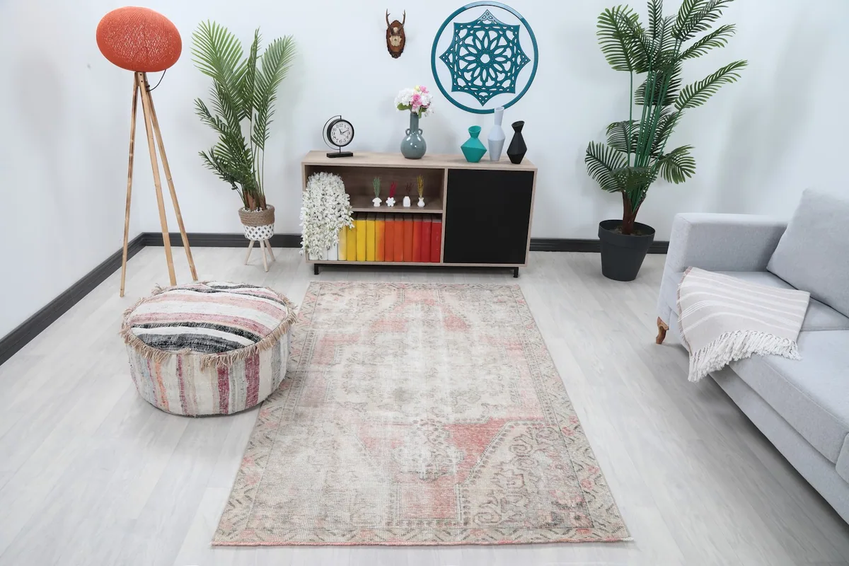 Vintage Anatolian rug in a living room setting with a sofa and ottoman