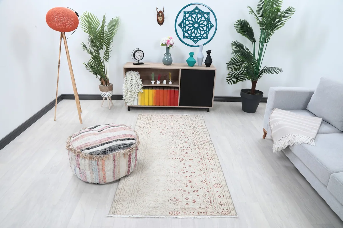 Ivory and rust area rug placed in a modern living room setting with a light couch