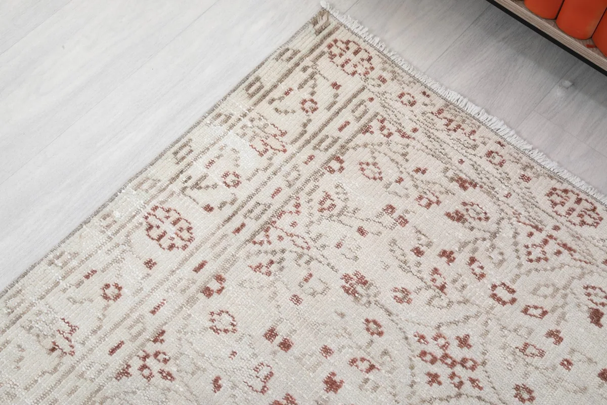 Detail of the rug's border, showing the geometric patterns and a slight angle