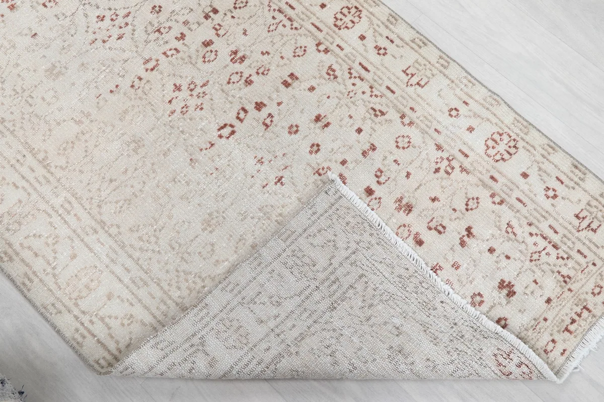 Corner of the rug folded to reveal the hand-knotted cotton foundation and reverse side