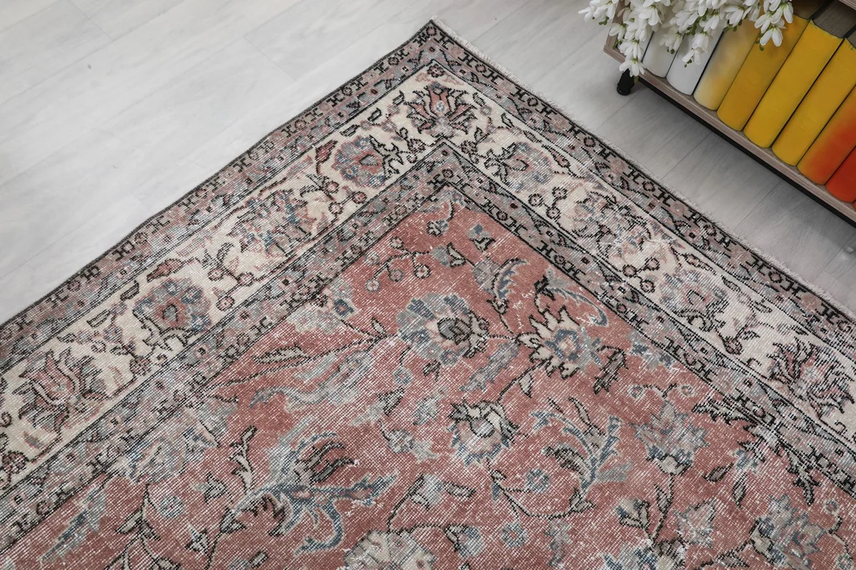 Corner detail of the vintage rug, highlighting the intricate border design and color blending