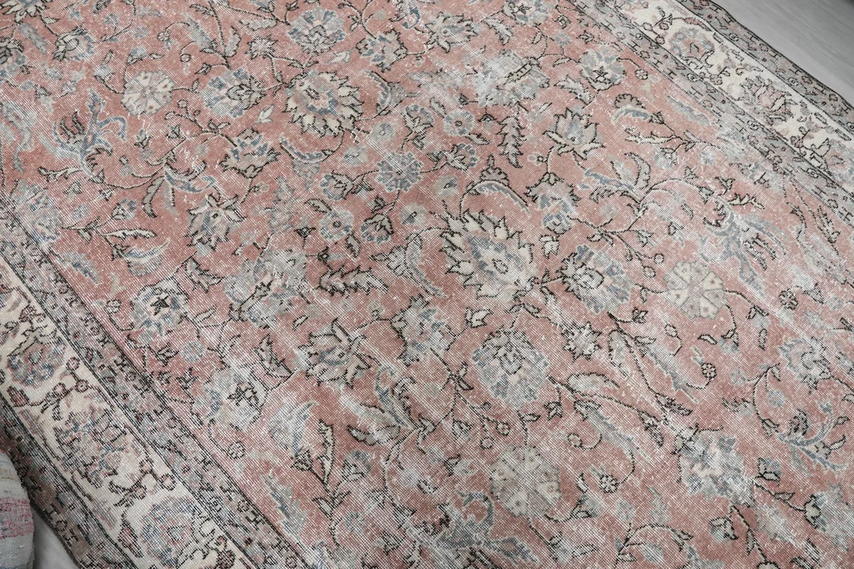 Close-up of the rose field and ivory floral motifs, showing natural wear and patina