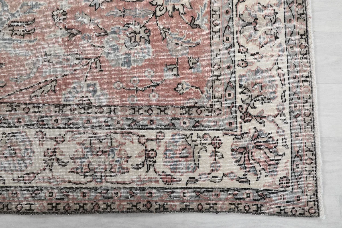 Detail of the rug's ivory and charcoal border with floral and geometric motifs