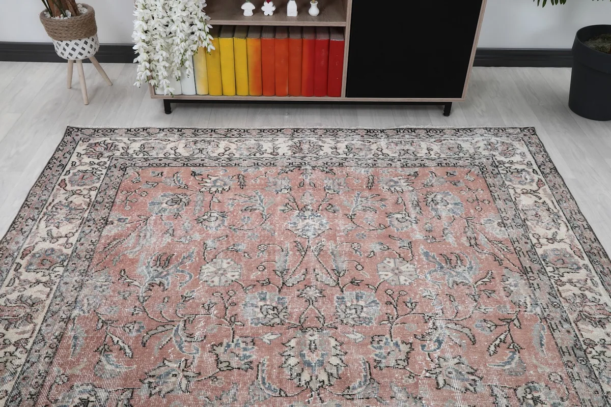 Overhead view focusing on the central area of the rose rug within a room