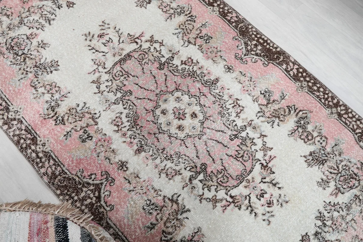 Overhead angled shot highlighting the central floral medallion and surrounding patterns of the rug