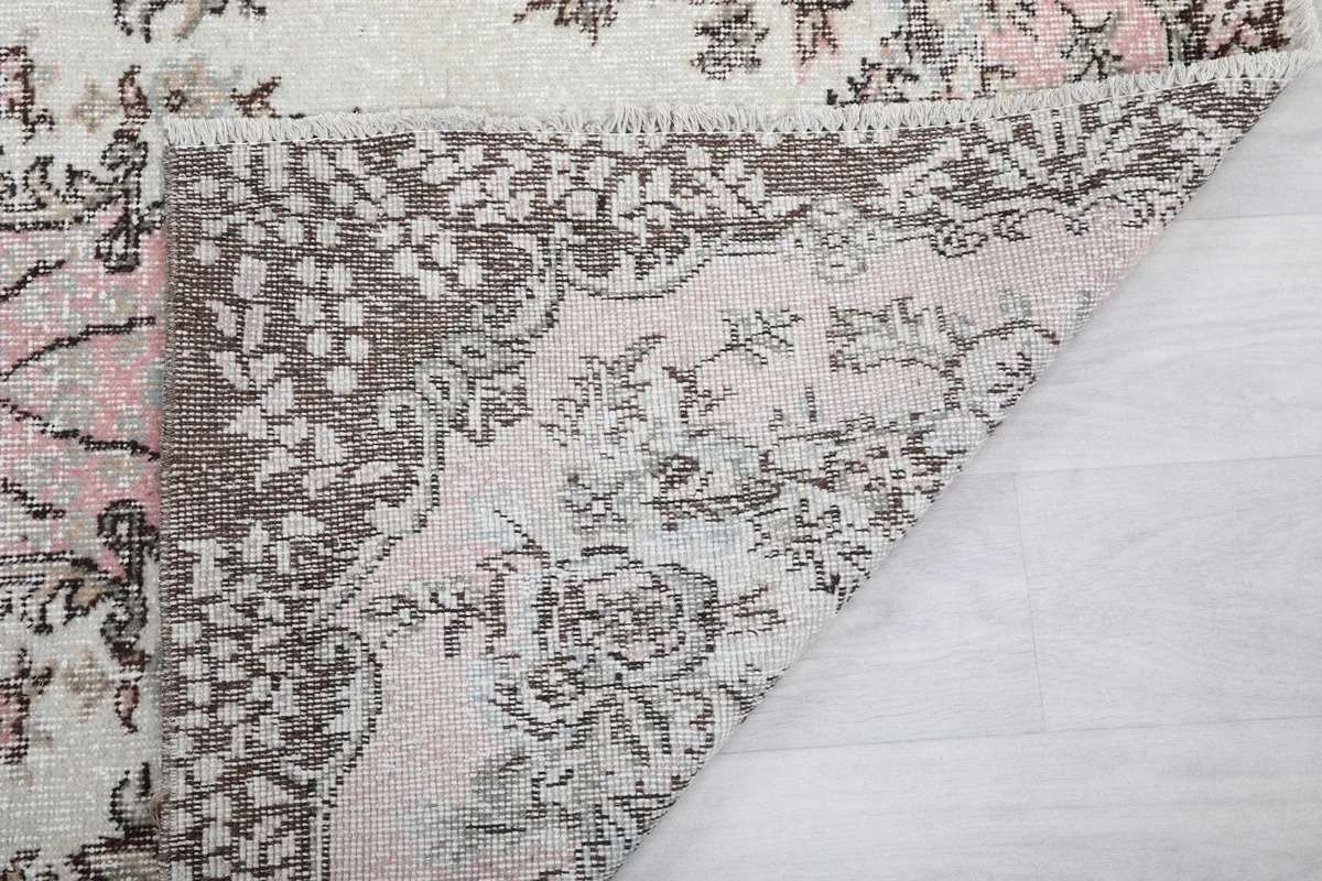 Another folded corner view of the rug, revealing the reverse side's weave and fringe