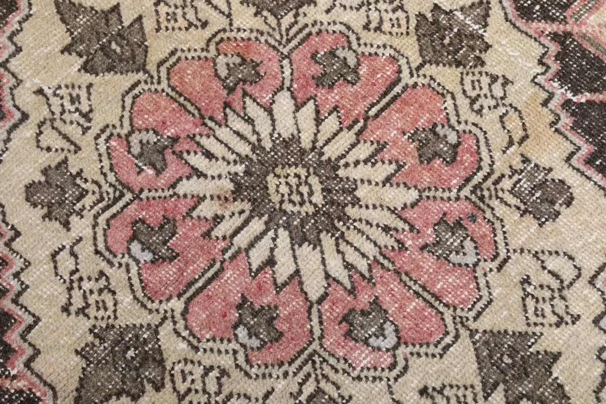 Macro close-up of the intricate floral-like pattern within the rug's central medallion