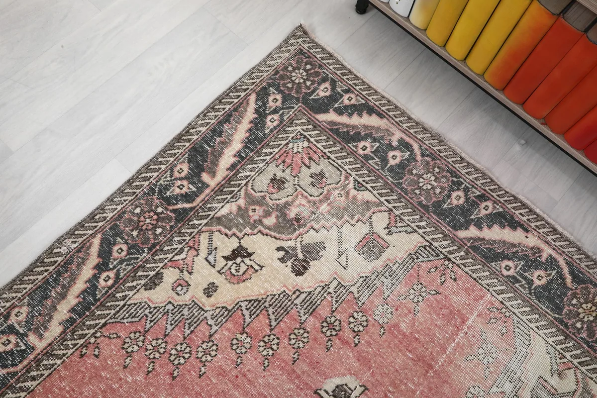 Close-up of the rug's border design, showing the detailed geometric motifs and color fading
