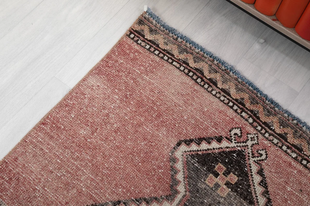 Detail of the rug's edge, showing the subtle border design and the rose field