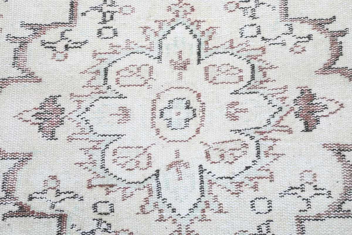 Detailed view of the hand-knotted wool pile and the worn texture of the medallion pattern.