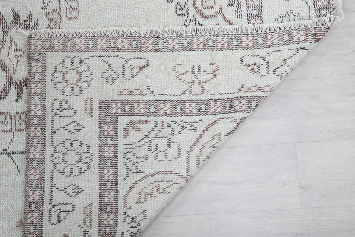 Another corner of the rug folded, showing the back of the rug and the tightly woven construction.