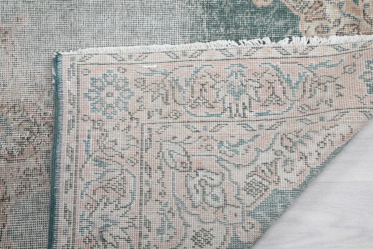 Close-up of the rug's back, showing the hand-knotted structure and fringe