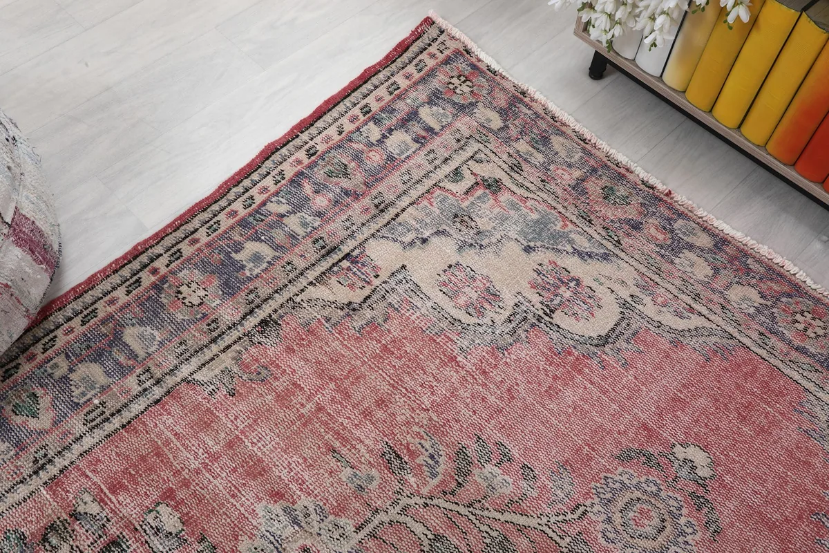 Corner detail of the rug, showing the border design and muted colors