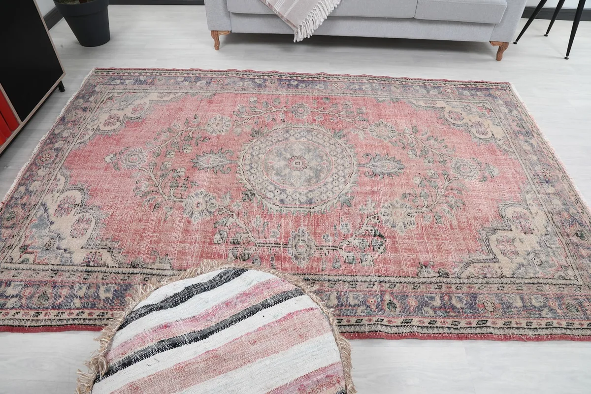 View of the rug in a room setting from a different perspective, with an ottoman