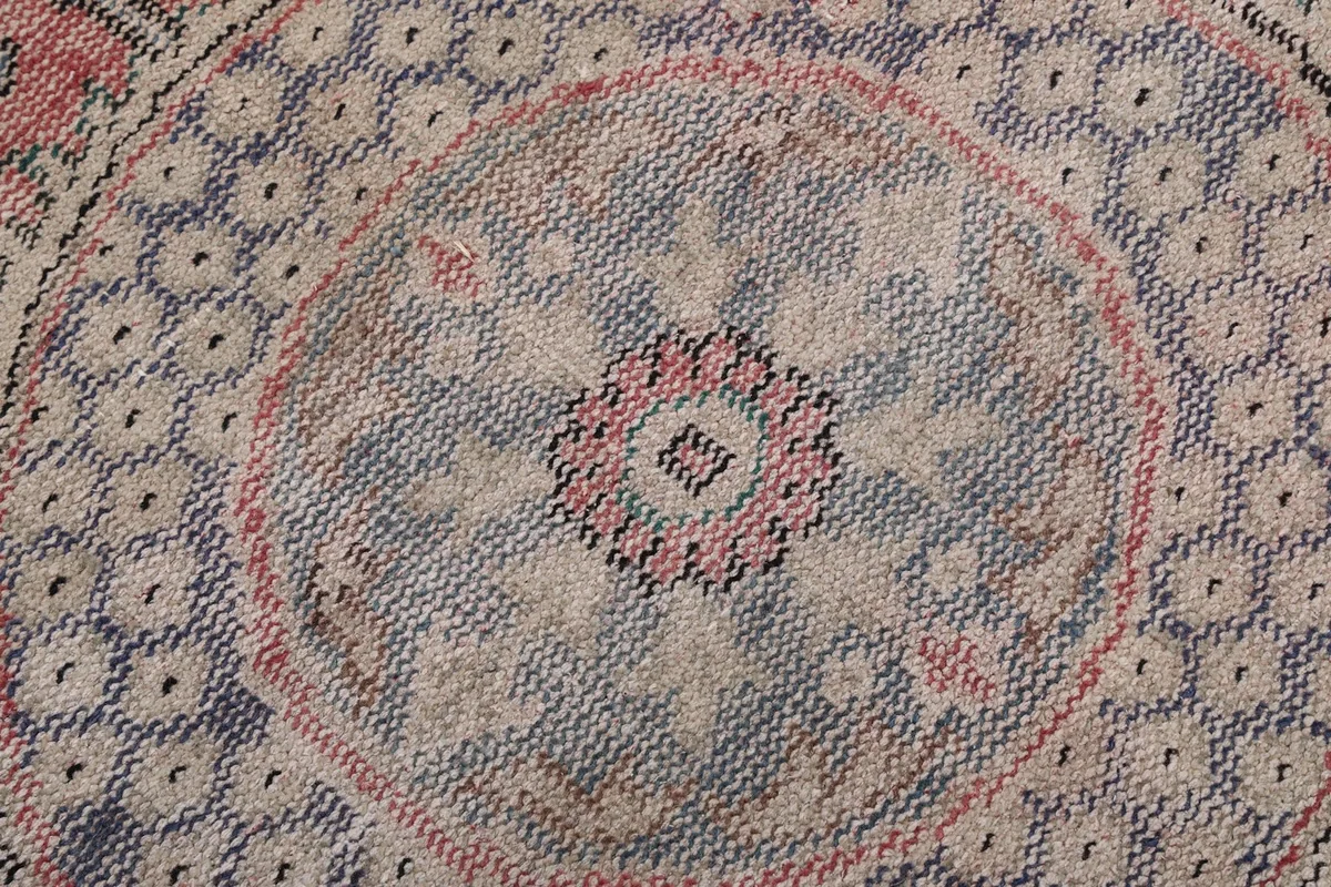Macro view of the intricate knotting and colors within the central medallion