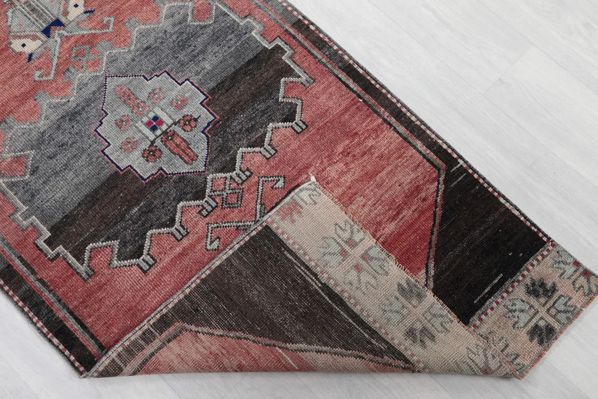 Corner of the rug folded to reveal the cotton foundation and reverse side of the knots